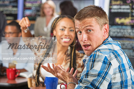 Angry young woman threatening rude man in cafe