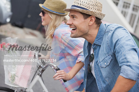 Hip young couple on their bikes on a sunny day in the city