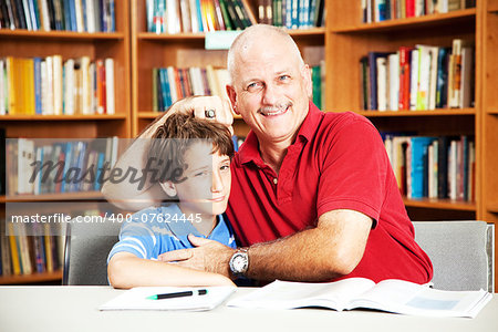 Annoying father teasing his son when they are supposed to be studying at the library.