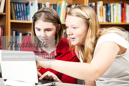 Teen girls using a computer in the library.