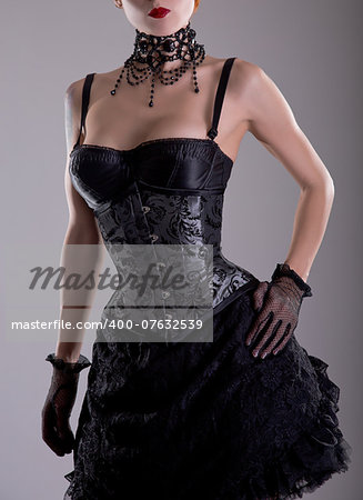 Elegant young woman in silver corset and black skirt, studio shot