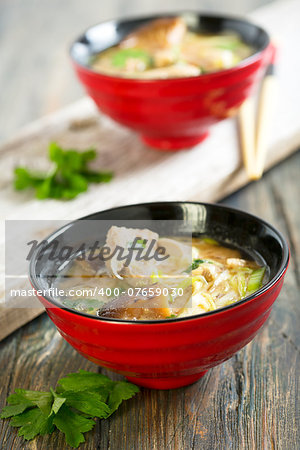 Miso soup with duck breast in red cups.