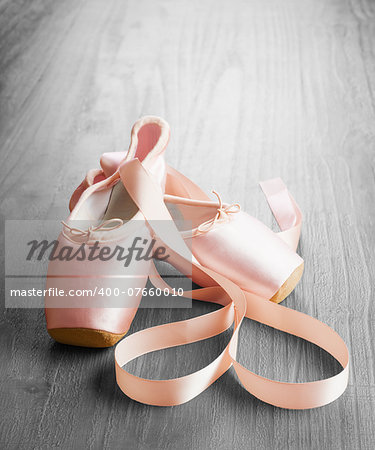 new pink ballet pointe shoes on vintage wooden background
