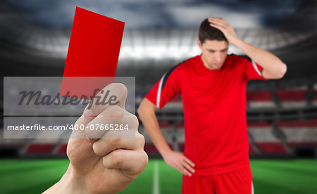 Hand holding up red card against stadium full of usa football fans with player