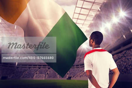 Football fan in white standing against football stadium