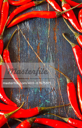 Red hot chili frame on an old wooden board with copy space.