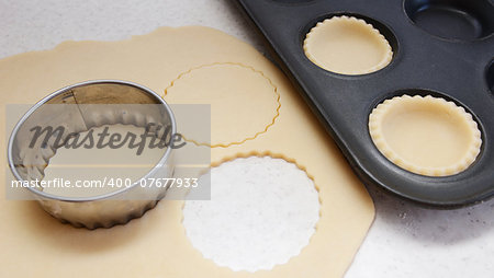 Cutting large circles of pastry to line a bun tin