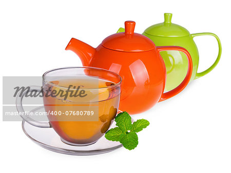 Glass cup of tea with mint leaves and two  teapots isolated on white background