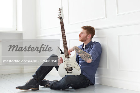 Handsome guy on the floor with electric guitar