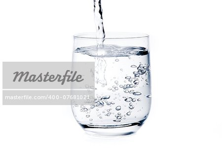 filling a glass with pure water and bubbles on white background