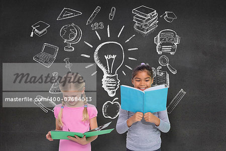 Elementary pupils reading against black wall with school doodles