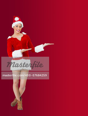 Pretty santa girl smiling at camera and presenting on red background