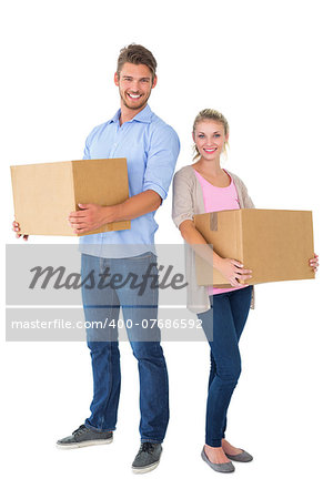 Attractive young couple carrying moving boxes on white background