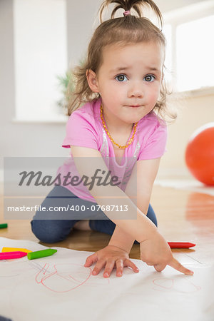 Little girl drawing in the living room at home