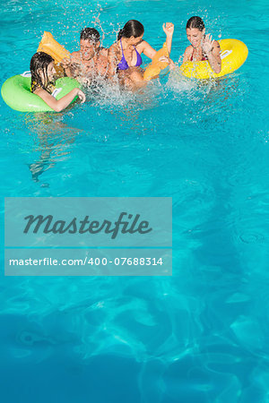 Cheerful young people playing in the swimming pool