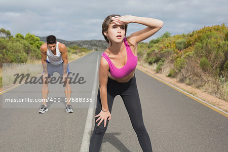Fit young couple running on the open road together
