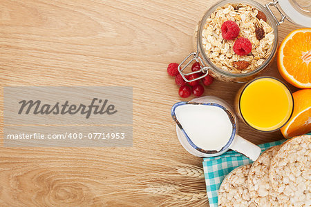 Healty breakfast with muesli, berries and orange juice. View from above on wooden table with copy space