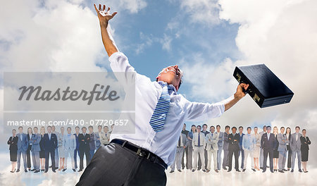 Businessman holding briefcase and cheering against blue sky with white clouds