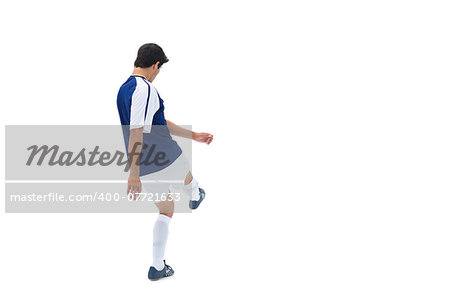 Football player in blue kicking on white background