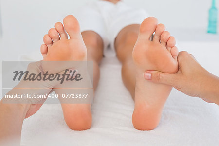 Close-up of a young woman receiving foot massage at spa center