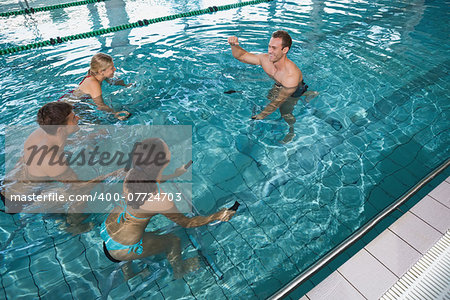 Fitness class doing aqua aerobics on exercise bikes in swimming pool at the leisure centre