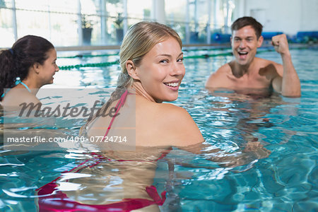 Fitness class doing aqua aerobics on exercise bikes in swimming pool at the leisure centre