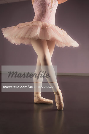 Ballerina standing in pink tutu in the ballet studio