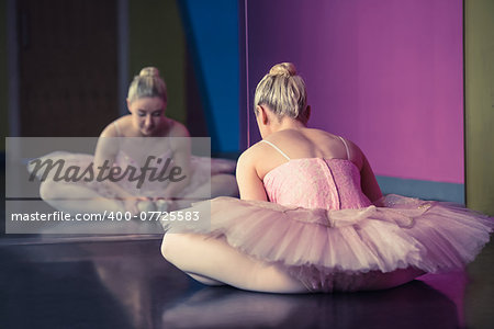 Graceful ballerina warming up in front of mirror in the ballet studio