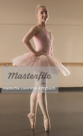 Beautiful ballerina standing en pointe in the dance studio