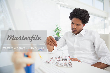 Hipster photo editor working at his desk in his office