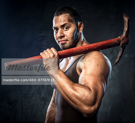 Muscular man holding pickaxe