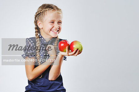 Ive got two ! Smiling cute little girl playing around with colofrul apples