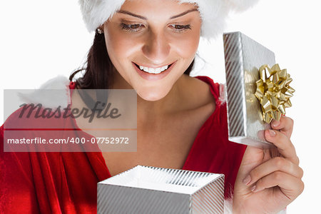 Smiling woman opening christmas present on white background