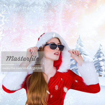 Cool santa girl wearing sunglasses against snowy landscape with fir trees