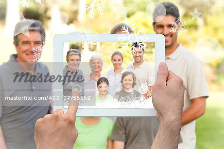 Hands holding tablet pc against family in the park