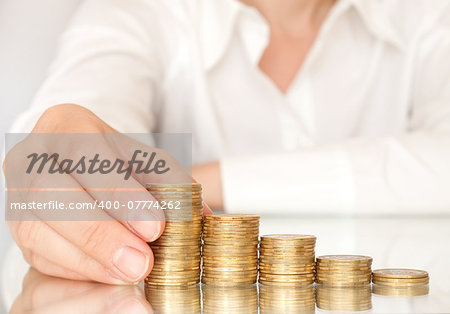 Hand put coins to stack of coins on white background