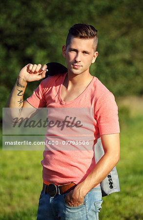 Fashion portrait of handsome young man smiling outdoors