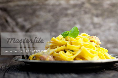 Italian cooking. Pasta spaghetti carbonara with ham, eggs and basil