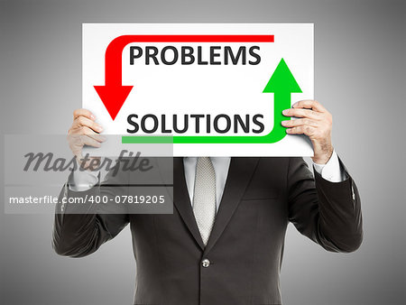 A business man holding a paper in front of his face with the text problems solutions
