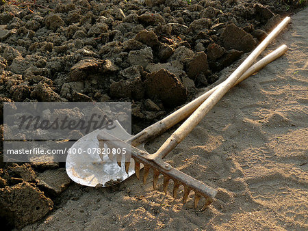 rake and spade at the edge of ploughed ground
