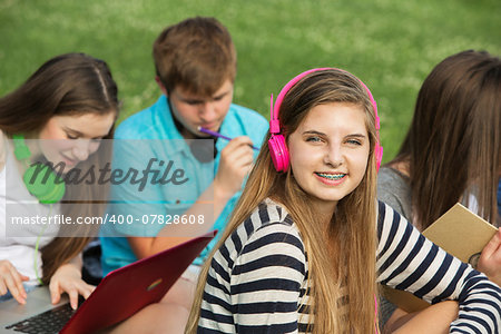 Smiling cute teen girl with braces and pink headphones
