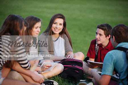 Happy young female student talking with friends