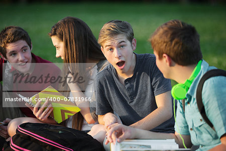 Surprised young student with group of friends outdoors