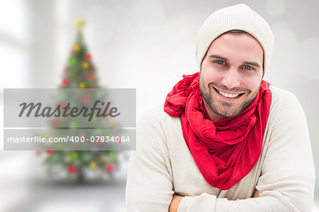 Handsome hipster against blurry christmas tree in room