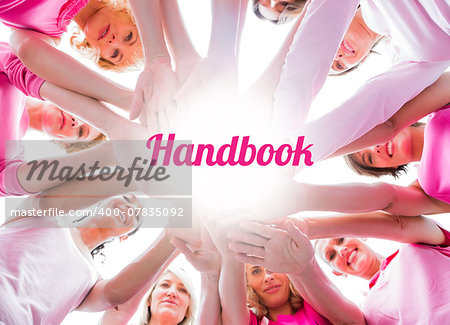 Diverse women smiling in circle wearing pink for breast cancer on white background
