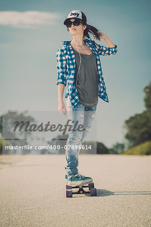 Young woman down the road with a skateboard