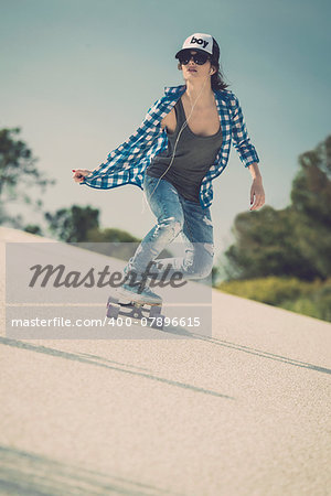 Young woman down the road with a skateboard