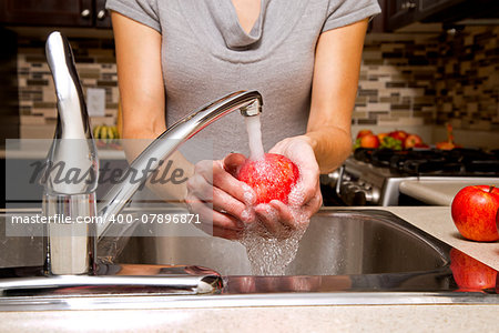 woman washing apples in the sink home kitchen