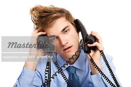 Young man sitting in the office and answering several phones at the same time