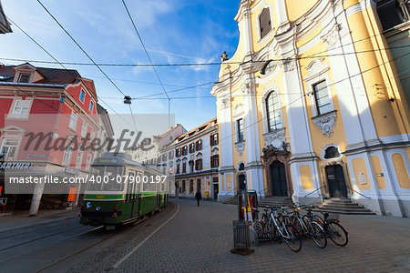 Graz, Austria - January 16, 2011: View of Annenstrasse street with typical green tram and Brotherhood Baroque Church in Graz, Austria